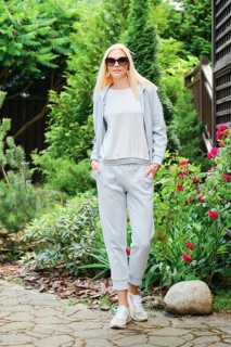 Sporty woman posing in grey tracksuit in the garden