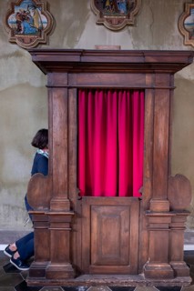 Woman Confesses Inside a Beautiful Church of San Carpoforo with Sunlight in Bissone