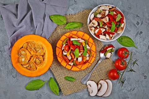 Top view of baked vegan Red kuri squash vegetable filled with bell pepper
