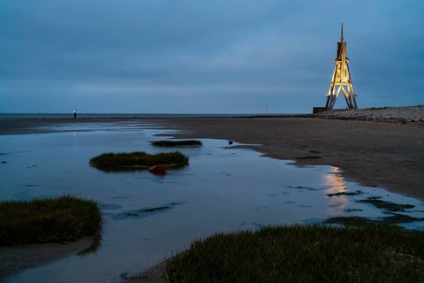 Kugelbake illuminated with water reflection at dusk