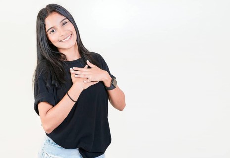 Grateful teenage girl smiling with hands on chest isolated. Positive latin girl with hands on chest. Thankful people with hands on heart