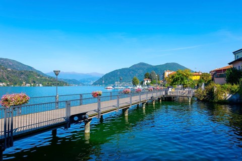 Elevated Walkway on Lake Lugano and City with Mountain in a Sunny Summer Day in Porto Ceresio
