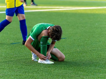 Young football player running across the pitch