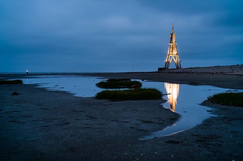 Kugelbake illuminated with water reflection at dusk