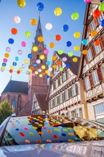 Colourful lanterns hanging in alleyway alley between half-timbered houses
