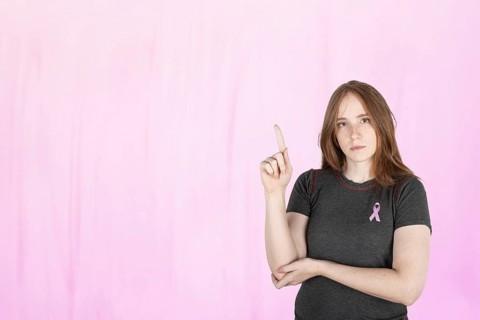 Woman wearing a pink breast cancer awareness ribbon. Concept of struggle with breast cancer