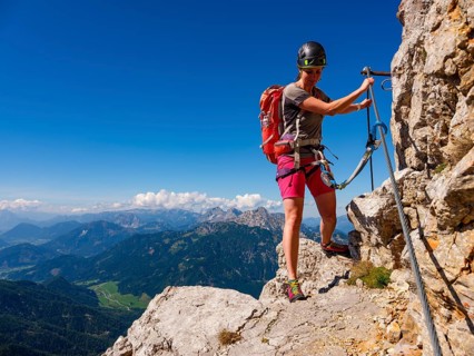 Young woman climbing the south face via ferrata on the Grosser Buchstein