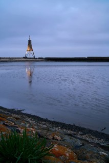 Kugelbake illuminated with water reflection at dusk