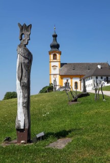 Wooden sculptures at the Stations of the Cross on Kirchberg with parish church