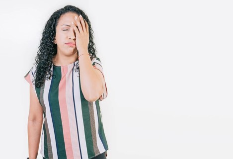 Stressed young woman holding her forehead. Stressed people with palm on forehead isolated. Worried young woman holding his forehead