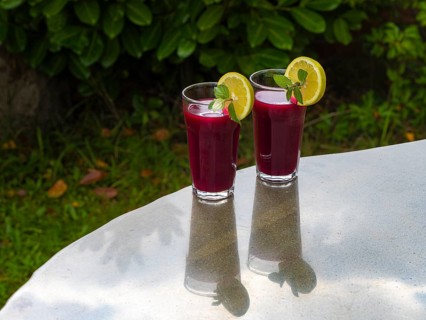 Freshly squeezed juice of beetroot with apple and lemon in a juice glass