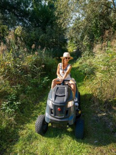 Woman driving lawn mower