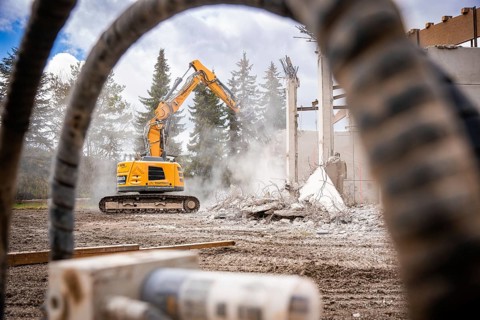 Yellow Liebherr crawler excavator recycling on demolition site