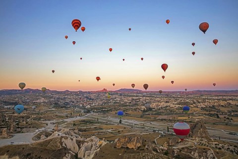 Hot air balloons flying over Cappadocia at sunrise