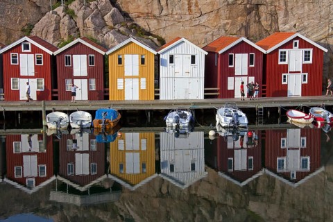Colourful traditional fishing huts and boathouses along wooden pier at Smoegen