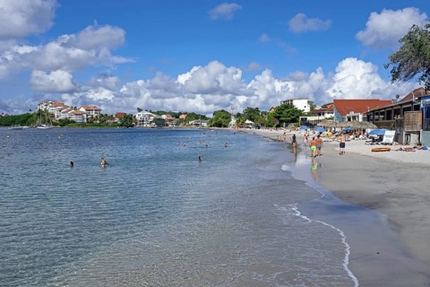 Tourists on sandy beach at Anse Mitan