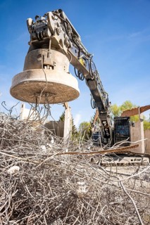 Black Liebherr crawler excavator with magnet recycling on demolition site