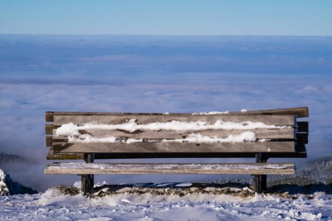 A frozen lookout bench with a view of the sea of fog at Brauneck in Lenggries