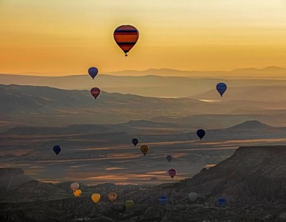 Hot air balloons flying over Cappadocia at sunrise