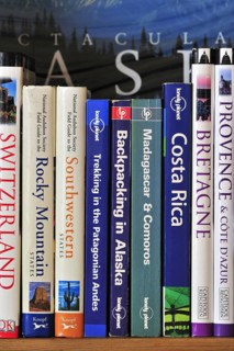 Collection of travel guides about worlwide holiday destinations on a bookshelf