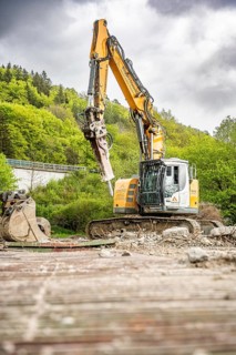 Yellow Liebherr crawler excavator recycling on demolition site