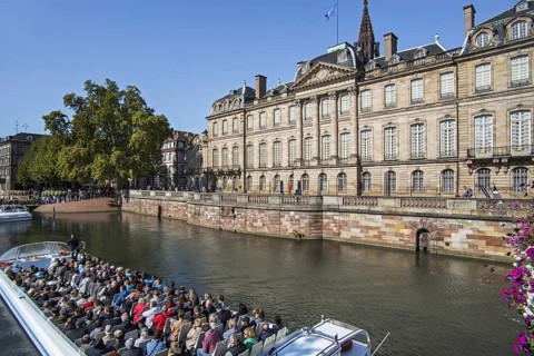 Excursion boat with tourists in front of the Palais Rohan