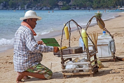 Beach vendor preparing corn on tiny portable barbecue on the island Ko Tao