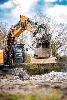 Yellow Liebherr crawler excavator with magnet recycling on demolition site