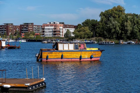Illegally anchored houseboats in the Rummelsburg Bay with the residential houses on the Rummelsburg shore