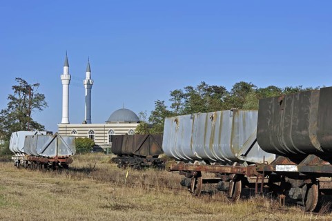 Minarets of the Turkish Islamic Fatih Mosque of immigrant workers and wagons of the coal mine museum at Beringen