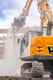 Yellow Liebherr crawler excavator recycling on demolition site