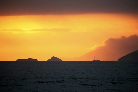 Three-master sailing ship at sunset in front of Santiago Island