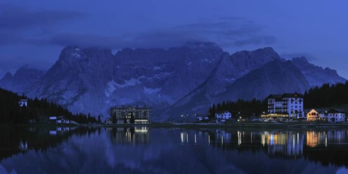 The mountain range Gruppo del Sorapis and hotels at night along lake Lago di Misurina in Auronzo di Cadore