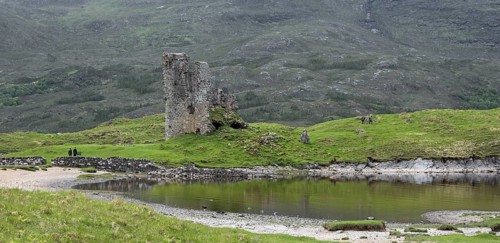 Tourists visiting 16th century Ardvreck Castle ruin at Loch Assynt in the Scottish Highlands