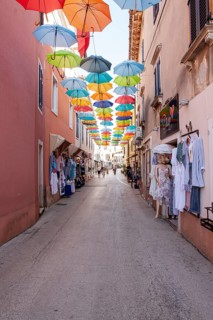 Alley with colourful umbrellas suspended over a street