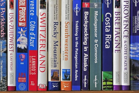Collection of travel guides about worlwide holiday destinations on a bookshelf