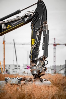 Black Liebherr crawler excavator excavating earth for house construction on building site