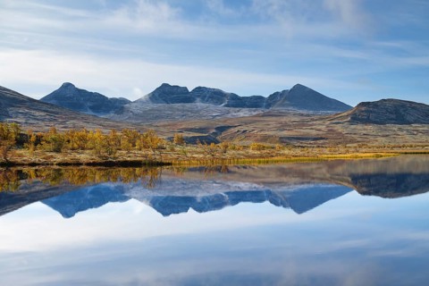 The mountains Hogronden and Digerronden reflected in the water of a lake