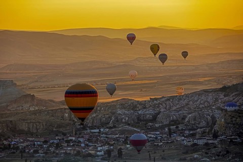 Hot air balloons flying over the town Goereme in Cappadocia at sunrise