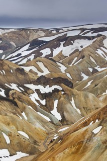 Sulphur coloured rhyolite mountains with patches of snow at Brennisteinsalda volcano near Landmannalaugar