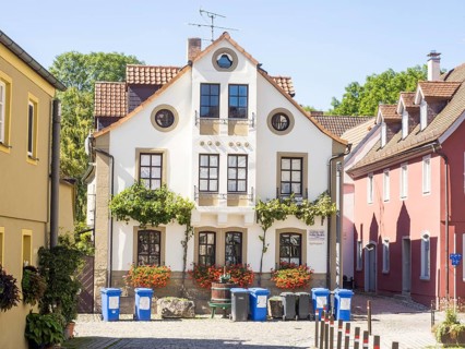Rubbish bin in front of a house with flower decorations