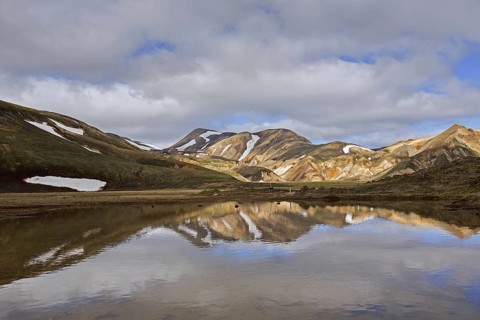 Lake and sulphur coloured rhyolite mountains at Brennisteinsalda volcano near Landmannalaugar