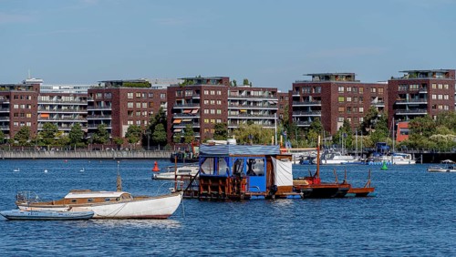 Illegally anchored houseboats in the Rummelsburg Bay with the residential houses on the Rummelsburg shore