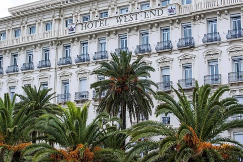 Palm trees and the Hotel West End along the Promenade des Anglais in the city Nice