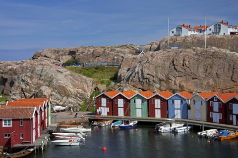 Colourful traditional fishing huts and boathouses along wooden pier at Smoegen
