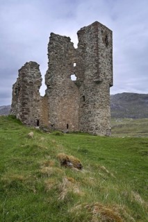 Tourists visiting 16th century Ardvreck Castle ruin at Loch Assynt in the Scottish Highlands