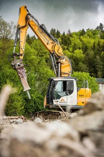 Yellow Liebherr crawler excavator recycling on demolition site