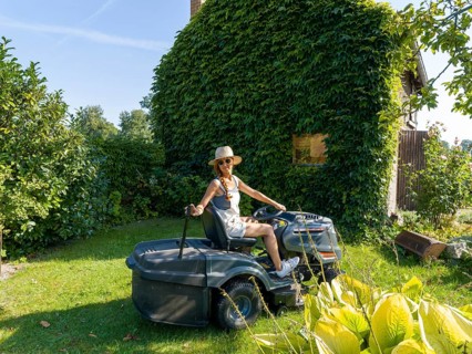 Woman driving lawn mower