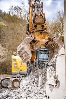 Yellow Liebherr crawler excavator recycling on demolition site
