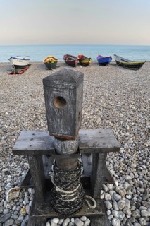 Old capstan and colourful traditional caiques